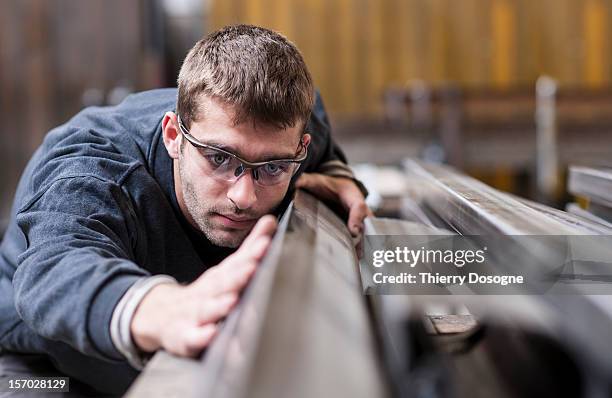 worker in metal worshop - worker inspecting steel stock pictures, royalty-free photos & images
