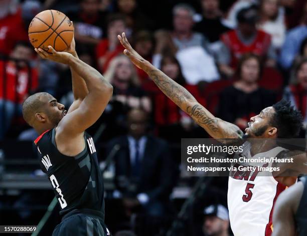 Houston Rockets guard Chris Paul takes a shot with Miami Heat forward Derrick Jones Jr. Defending during the third quarter of an NBA basketball game...
