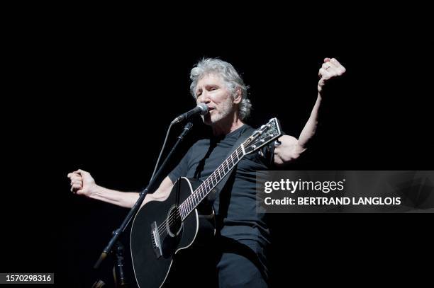 Roger Waters, bassist from the Rock group Pink Floyd, gestures during a performance of The Wall at the Bercy POPB concert hall in Paris on May 30,...