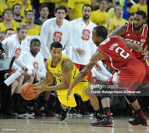 North Carolina State Wolfpack's Lorenzo Brown and Richard Howell, right, double team Michigan Wolverines point guard Trey Burke in front of their...