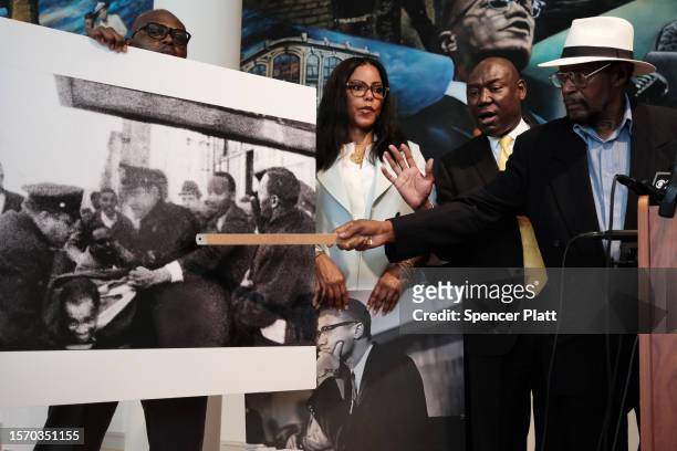 Mustafa Hassan an associate of Malcolm X, points to himself in a picture following the assassination of Malcolm X during a news conference with Civil...