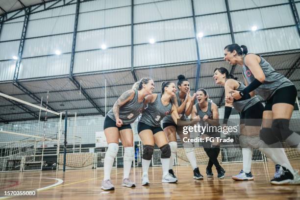 squadra di pallavolo femminile che festeggia dopo aver vinto una partita sul campo sportivo - pallavolo foto e immagini stock