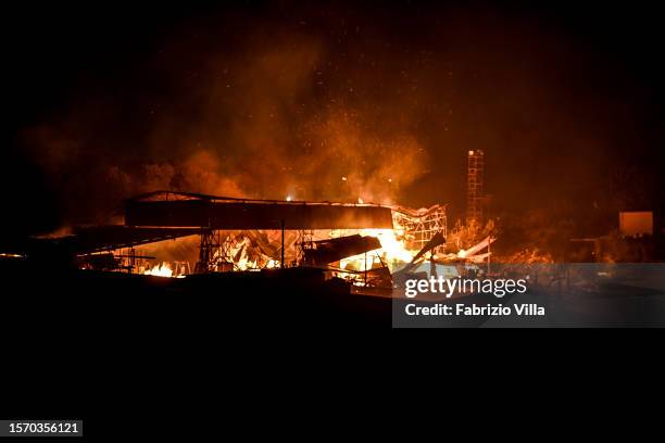 An abandoned shed engulfed in flames is one of several fires that spread this evening, fuelled by strong winds in the province of Catania on July 25,...