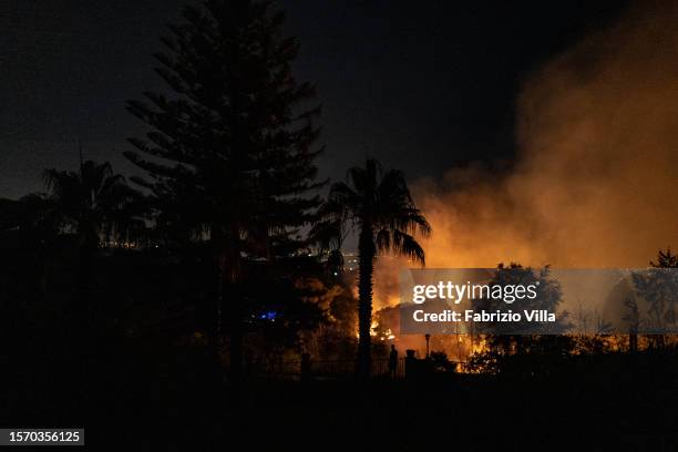 Garden full of plants is invaded by flames, one of many fires that spread in the evening fuelled by strong winds in the province of Catania on July...