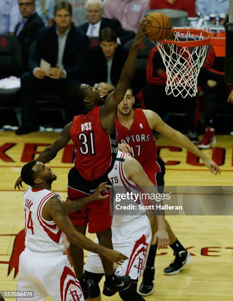 Terrence Ross of the Toronto Raptors dunks over Omer Asik and Daequan Cook of the Houston Rockets at the Toyota Center on November 27, 2012 in...