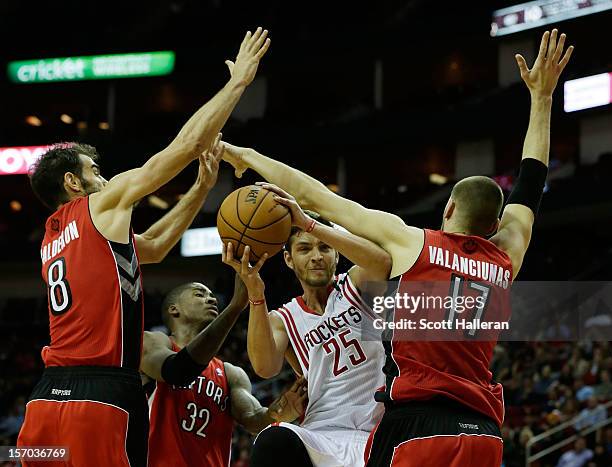 Chandler Parsons of the Houston Rockets drives between Jose Calderon, Ed Davis and Jonas Valanciunas of the Toronto Raptors at the Toyota Center on...