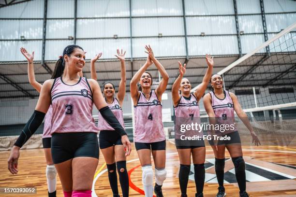squadra di pallavolo femminile che festeggia dopo aver vinto una partita sul campo sportivo - competizione di pallavolo foto e immagini stock