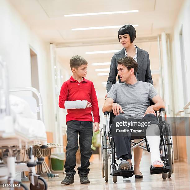 vater und sohn im krankenhaus - gebrochener arm stock-fotos und bilder