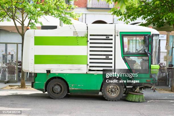 close-up of a cleaning truck sweeping the city streets outside of buildings, side view - valladolid spanish city stockfoto's en -beelden