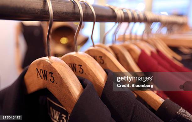 Ladies' clothes hang on branded hangers inside a NW3 store, a brand of Hobbs and former pop-up store, in London, U.K., on Tuesday, Nov. 27, 2012....