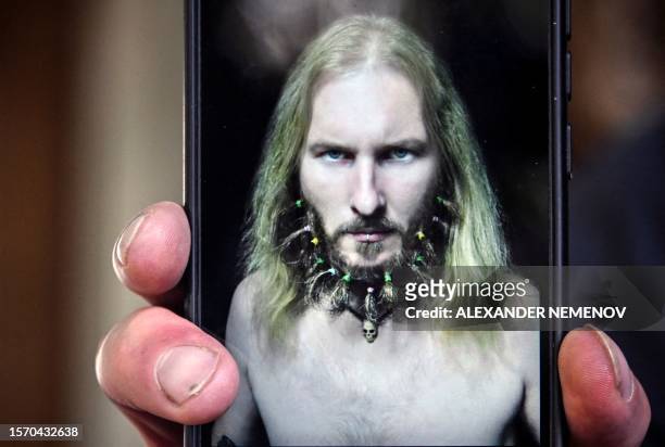 Musician Valentin Sokhorev shows his mobile phone with the photo of his late friend Anatoly Berezikov on its screen in the village of Davydkovo,...