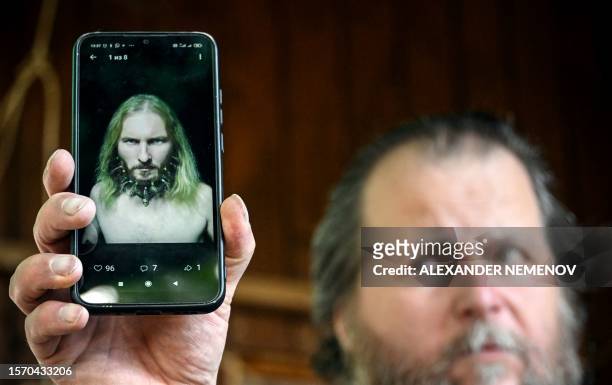 Musician Valentin Sokhorev shows his mobile phone with the photo of his late friend Anatoly Berezikov on its screen in the village of Davydkovo,...