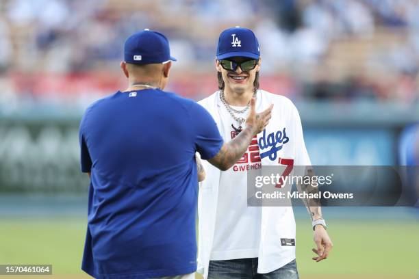 Rapper Peso Pluma shares a moment with Julio Urias of the Los Angeles Dodgers prior to a game between the Los Angeles Dodgers and the Pittsburgh...