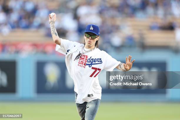 Rapper Peso Pluma throws the first pitch prior to a game between the Los Angeles Dodgers and the Pittsburgh Pirates at Dodger Stadium on July 05,...