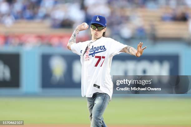 Rapper Peso Pluma throws the first pitch prior to a game between the Los Angeles Dodgers and the Pittsburgh Pirates at Dodger Stadium on July 05,...