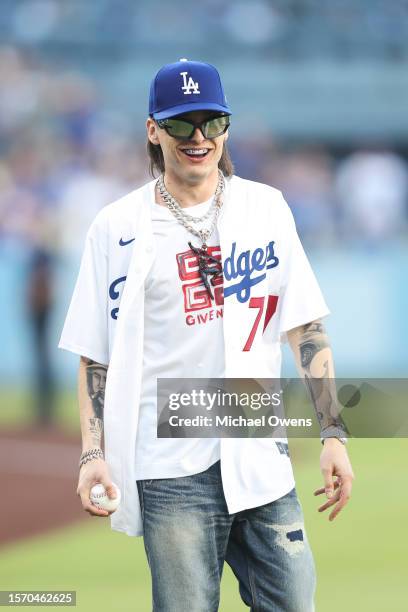 Rapper Peso Pluma reacts before throwing the first pitch prior to a game between the Los Angeles Dodgers and the Pittsburgh Pirates at Dodger Stadium...