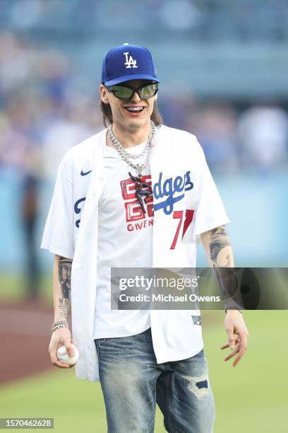 Rapper Peso Pluma reacts before throwing the first pitch prior to a game between the Los Angeles Dodgers and the Pittsburgh Pirates at Dodger Stadium...