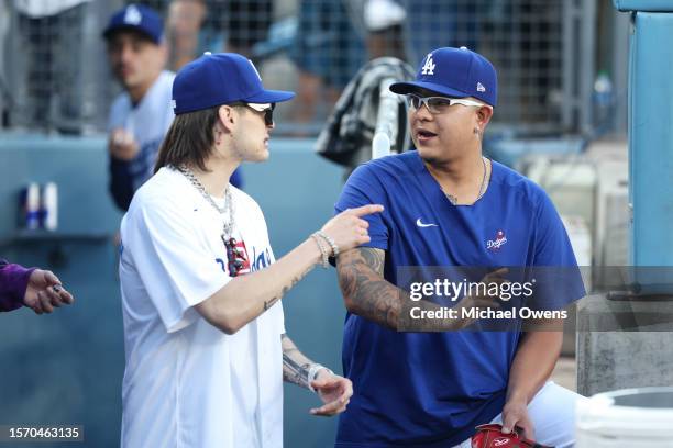 Rapper Peso Pluma chats with Julio Urias of the Los Angeles Dodgers before throwing the first pitch prior to a game between the Los Angeles Dodgers...