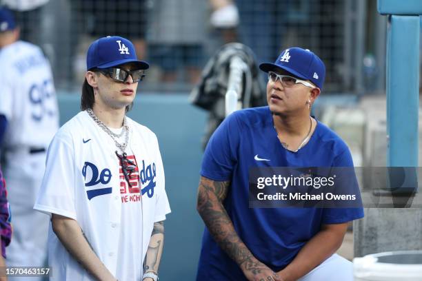 Rapper Peso Pluma chats with Julio Urias of the Los Angeles Dodgers before throwing the first pitch prior to a game between the Los Angeles Dodgers...