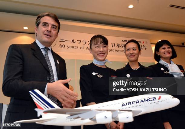 Air France-KLM chairman and CEO Alexandre de Juniac smiles with cabin attendants at a press conference in Tokyo on November 28, 2012. Juniac is in...