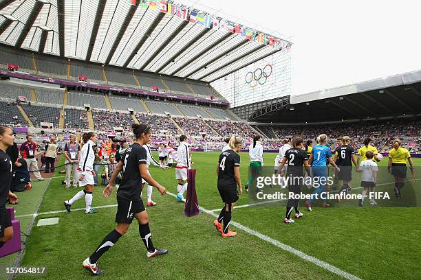 The teams walk onto the pitch prior to the Women's Football Quarter Final match between United States and New Zealand, on Day 7 of the London 2012...