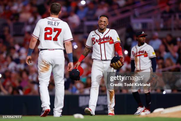 Orlando Arcia brings out the cap and glove to Austin Riley of the Atlanta Braves during the ninth inning against the Los Angeles Angels at Truist...