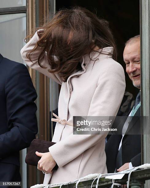 Catherine, Duchess of Cambridge moves her hair from her face on the balcony of Cambridge Guildhall as she pays an official visit to Cambridge with...