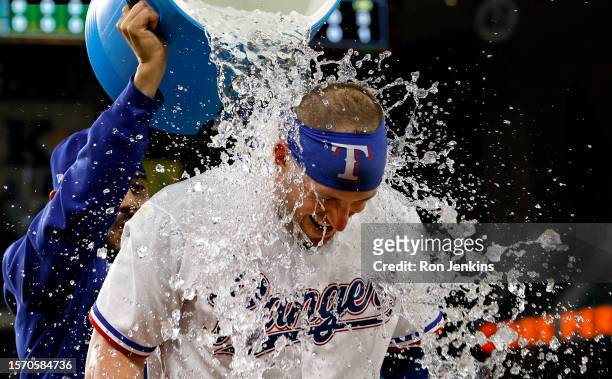 Mitch Garver of the Texas Rangers is doused with ice water by teammate Martin Perez following the team's 2-0 win over the Chicago White Sox at Globe...