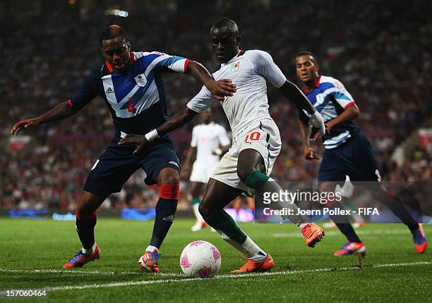 Danny Rose of Great Britain and Sadio Mane of Senegal compete for the ball during the Men's Football first round Group A Match of the London 2012...