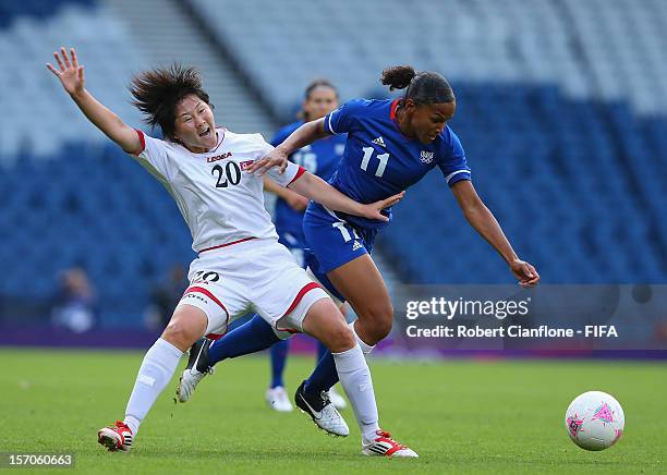 Yong Sim Choe of Korea DPR is challenged by Marie-Laure Delie of France during the Women's Football first round Group G Match of the London 2012...