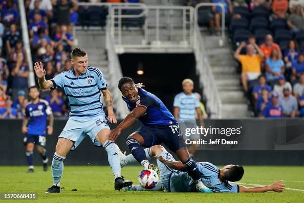 Sergio Santos of FC Cincinnati is tackled by Roger Espinoza of Sporting Kansas City during the second half of a Leagues Cup match at TQL Stadium on...