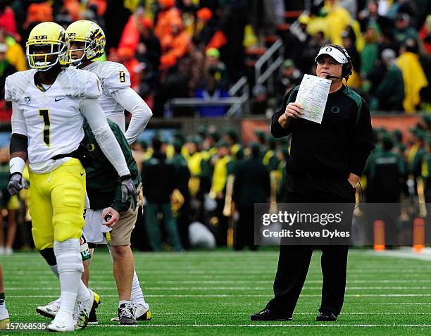 Head coach Chip Kelly of the Oregon Ducks speaks with wide receiver Josh Huff and quarterback Marcus Mariota of the Oregon Ducks in the third quarter...