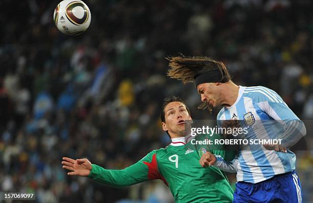 Argentina's defender Martin Demichelis heads the ball past Mexico's striker Guillermo Franco during the 2010 World Cup round of 16 football match...