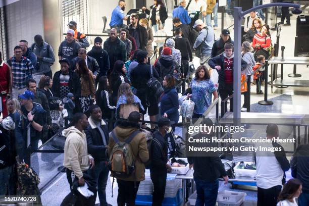 Passengers line up for security screening in Terminal C at George Bush Intercontinental Airport on Sunday, Jan. 13 in Houston. The impact of the...