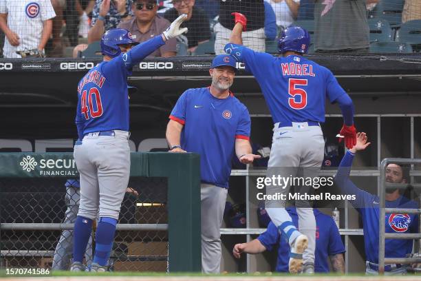 Christopher Morel of the Chicago Cubs high fives manager David Ross after hitting a solo home run against the Chicago White Sox during the second...