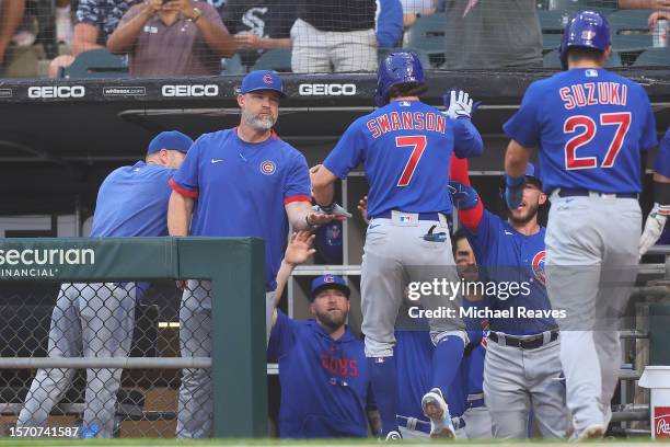 Dansby Swanson of the Chicago Cubs high fives manager David Ross after hitting a two-run home run against the Chicago White Sox during the second...