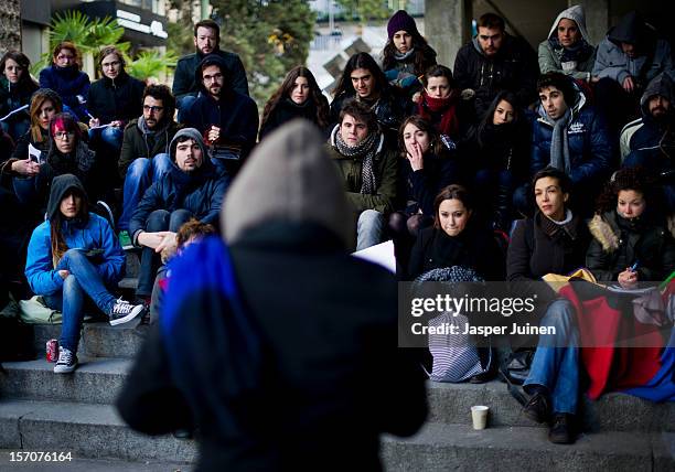 Sociology students brave the cold as they sit on the steps under the Juan Bravo bridge during a university class given by professor Elena Casado...