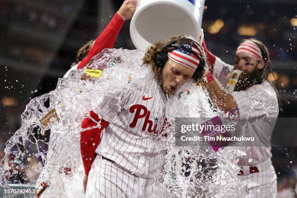 Alec Bohm of the Philadelphia Phillies receives a water shower after hitting a walk-off RBI single against the Baltimore Orioles at Citizens Bank...