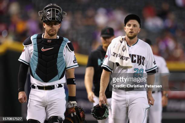 Catcher Carson Kelly and starting pitcher Merrill Kelly of the Arizona Diamondbacks walk to the dugout before the MLB game against the St. Louis...
