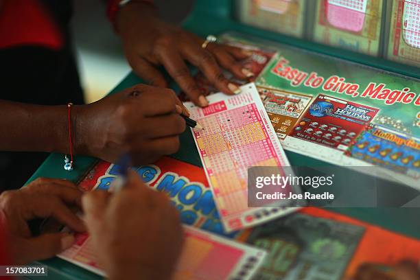 Monti Young fills out her Powerball numbers as she buys a ticket at Circle News Stand on November 28, 2012 in Hollywood, Florida. The jackpot for...