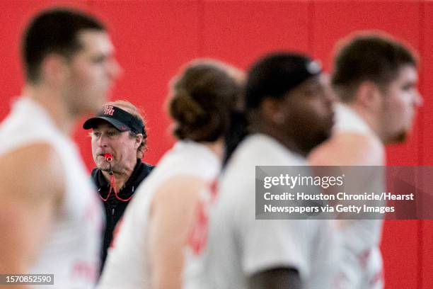 University of Houston head coach Dana Holgorsen watches his players run through a workout during the first day of spring practice on Tuesday, March...