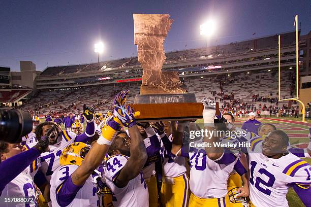 Players of the LSU Tigers carry The Boot trophy after the game against the Arkansas Razorbacks at Razorback Stadium on November 23, 2012 in...