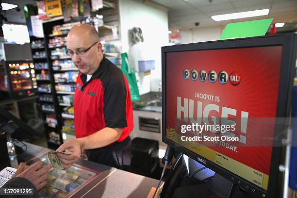 Jim Bayci sells a Powerball lottery ticket at his 7-Eleven store on November 28, 2012 in Chicago, Illinois. Bayci estimates more than half of his...