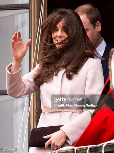 Catherine, Duchess of Cambridge's hair is blown in the wind as she stands on the balcony of The Guildhall during her and husband Prince William, Duke...