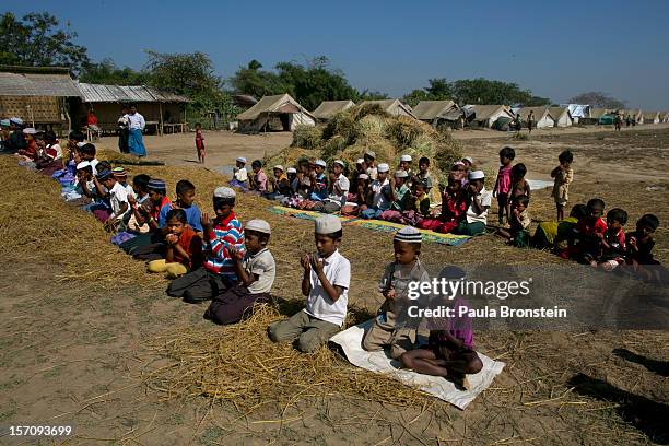 Rohingya boys pray during Friday prayers at a tented internally displaced persons camp November 23, 2012 on the outskirts of Sittwe, Myanmar. An...