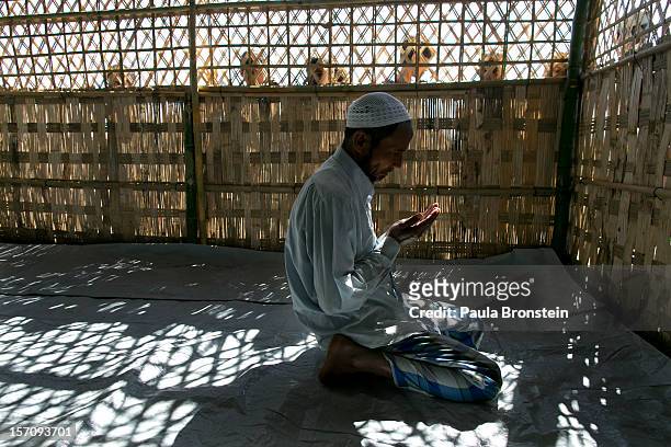 Rohingya man prays inside a makeshift mosque during Friday prayers at an internally displaced persons camp November 23, 2012 on the outskirts of...