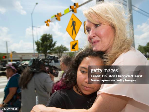 Teri Webb embraces her neice Ava Adams-Marsh near a newly-installed crosswalk light that was put in as part of the city's Safer Streets initiative on...