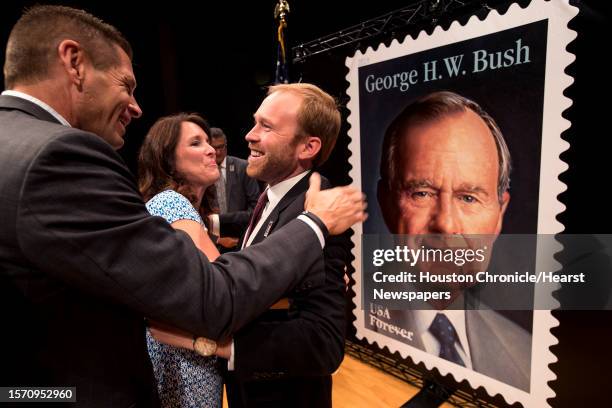 Wade and Julie Hopkins, of The Woodlands, embrace Pierce Bush, following the unveiling ceremony of the Forever Stamp honoring his grandfather, former...