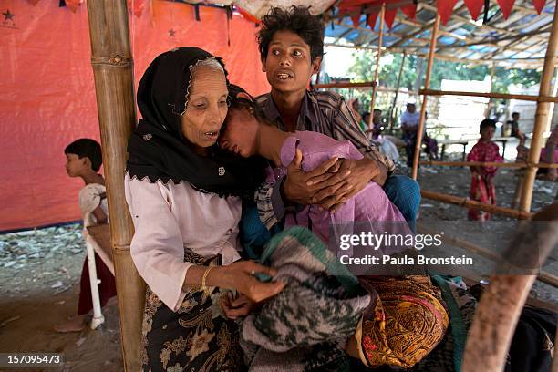 Mohammed Shamim holds his sick wife Mumtaz as her mother comforts her at a government run medical clinic November 25, 2012 on the outskirts of...