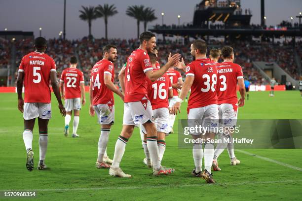 Ben Tozer congratulate Elliott Lee of Wrexham after he scored during the first half of a pre-season friendly match between Manchester United and...